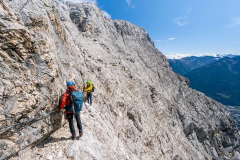 Two climbers on a via ferrata on a steep rock face