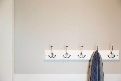 Wall in house with scarf hanging on coat rack hooks abstract