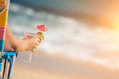 Woman relaxing on beach with tropical drink