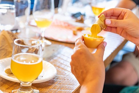 Woman enjoys warm pretzels and micro brew beer