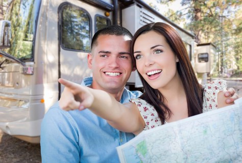 Young military couple looking at map in front of RV