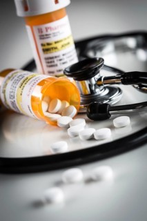 Non-Proprietary medicine prescription bottles and spilled pills abstract with stethoscope