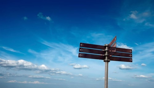 Blank signpost in sky with clouds