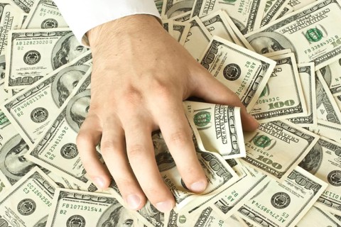 Greedy hand grabs money lot of dollars