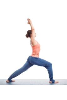 Beautiful sporty fit yogini woman practices yoga asana Virabhadrasana 1