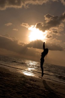 Girl jumping on sunrise at the beach