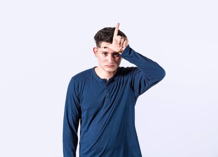 Unhappy man holding hand near forehead showing loser gesture with fingers