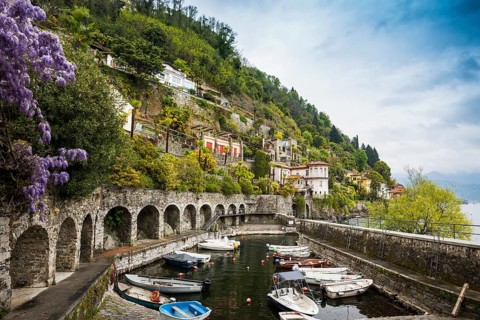 Small boat harbour and colourful villas on the lakeside