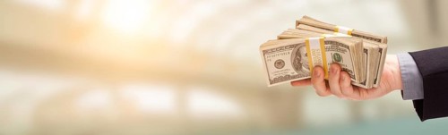 Male hand holding stack of cash wide banner with room for copy