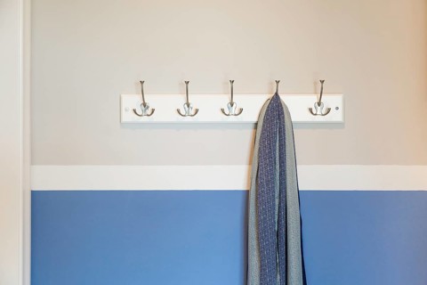 Wall in house with scarf hanging on coat rack hooks abstract