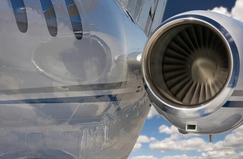 Private jet and engine abstract over clouds and sky
