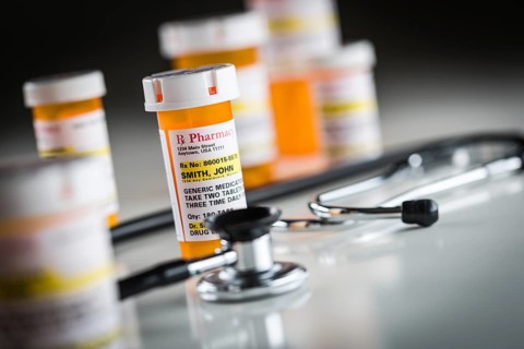 Several non-proprietary medicine prescription bottles abstract with stethoscope