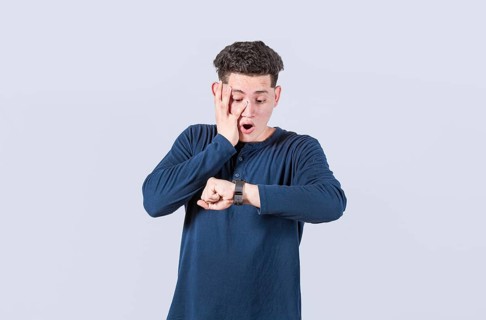 Young man looking at the watch time worried