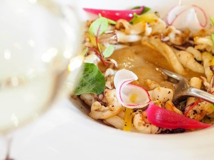 Macro close up of atlantic squid plated with potato rich sauce cream reduction