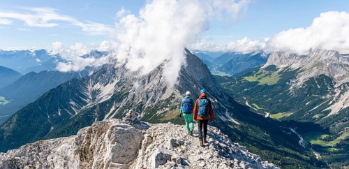 Hiker with climbing helmet on a steep rocky ridge
