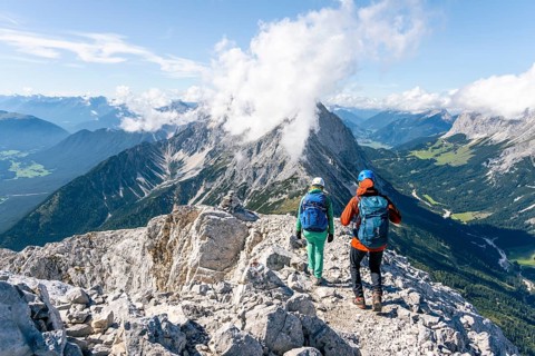 Hiker with climbing helmet on a steep rocky ridge