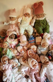 Various decorative dolls and baby dolls lying together