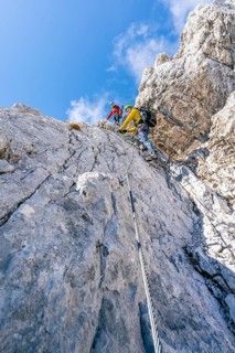 Climber on a via ferrata on a steep rock face