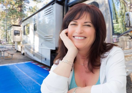 Attractive middle aged woman outdoor portrait in front of class A RV