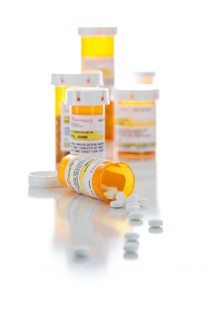 Non-Proprietary medicine prescription bottles and spilled pills isolated on a white background
