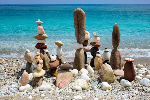Concept of balance and harmony. Stones pebbles stacks on the beach coast of the blue sea in the nature. Meditative art of stone stacking