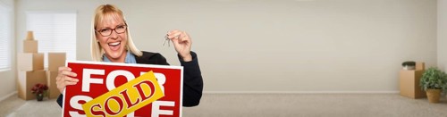 Banner of adult woman inside room with boxes holding house keys and sold for sale real estate sign