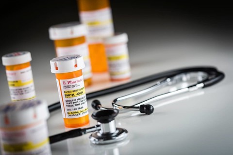 Several non-proprietary medicine prescription bottles abstract with stethiscope