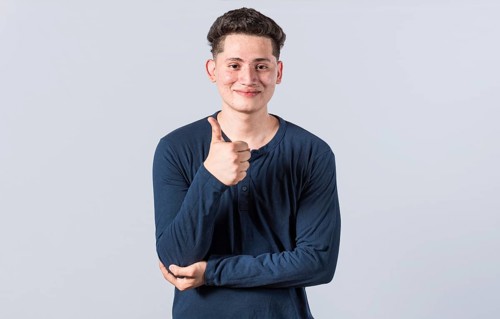 Smiling man showing ok gesture looking at camera