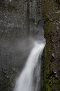 Waterfall flowing through small rock hole