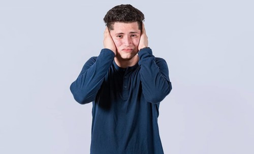 A guy covering his ears