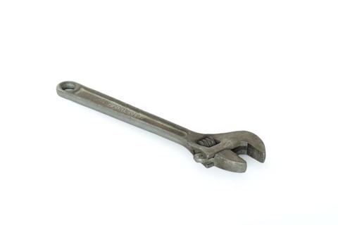 Old adjustable spanner isolated on white background