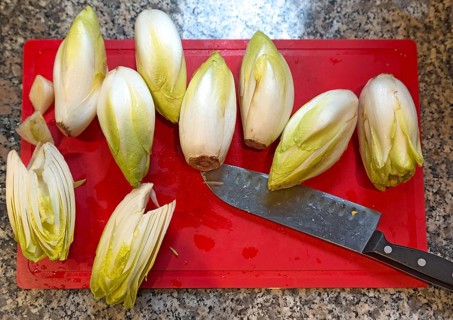 Fresh chicory with knife on a cutting board