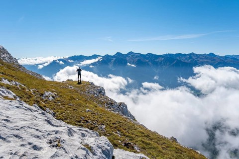 Hiker with climbing helmet on a steep rocky ridge