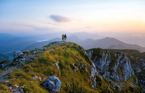 Two hikers at the summit of the Benediktenwand at sunset