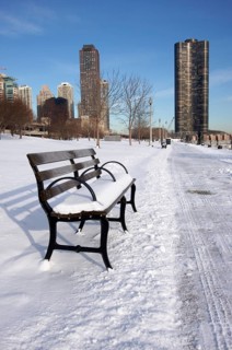 Empty snowy bench in chicago after winter snow along lake shore drive