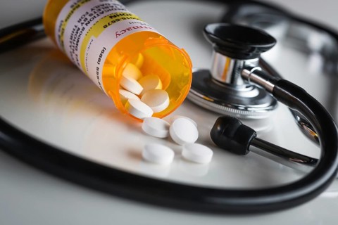 Non-Proprietary medicine prescription bottles and spilled pills abstract with stethoscope