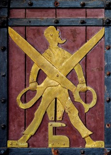 Historical figure on the door to the Ratskeller representing the tailor's trade