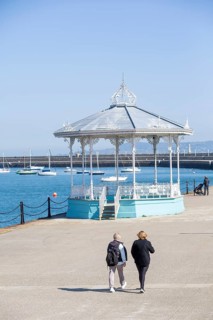 Promenade with passers-by and pavilion at Dun Laoghaire on a nice day. County Dublin