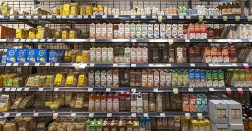 Shelves with different types of milk in tetra packs in an organic supermarket