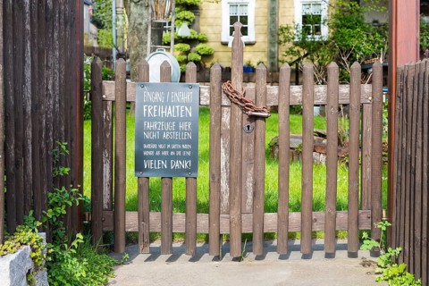 Locked garden gate of a restaurant with notice