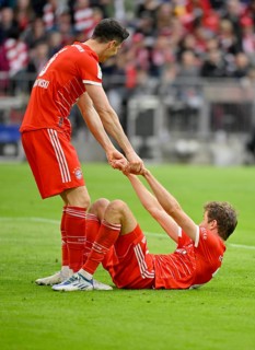 Robert Lewandowski FC Bayern Munich FCB helps Thomas Mueller FC Bayern Munich FCB to his feet