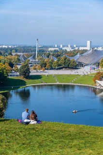 Two people sitting in the park with Olympic lake