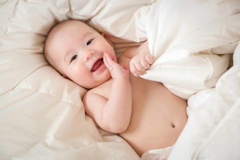 Young mixed-race chinese and caucasian baby boy having fun on his blanket