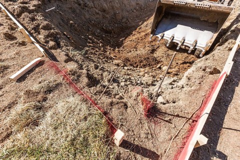 Small bulldozer digging in yard for pool installation