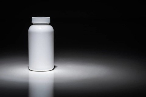 Blank white bottle ready for your text under spot light