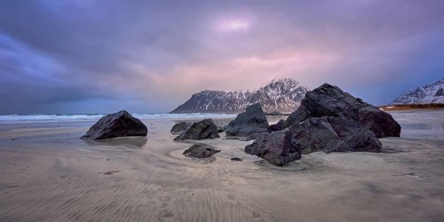 Beach of Norwegian sea on rocky coast in fjord on sunset. Skagsanden beach