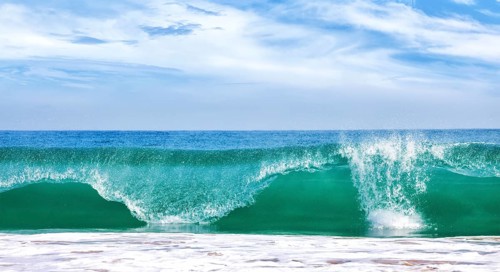 Big wave in ocean with blue sky