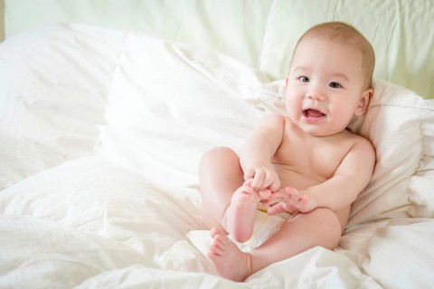 Young mixed-race chinese and caucasian baby boy having fun on his blanket