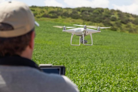 UAV drone pilot flying and gathering data over country farm land