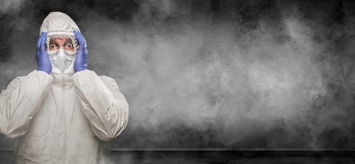 Man wearing hazmat suit and goggles in smokey room banner with copy space